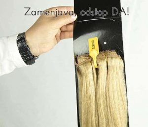Roka z uro drži paket blond lasnih podaljškov na belem ozadju z napisom 'Zamenjava, odstop DA!'