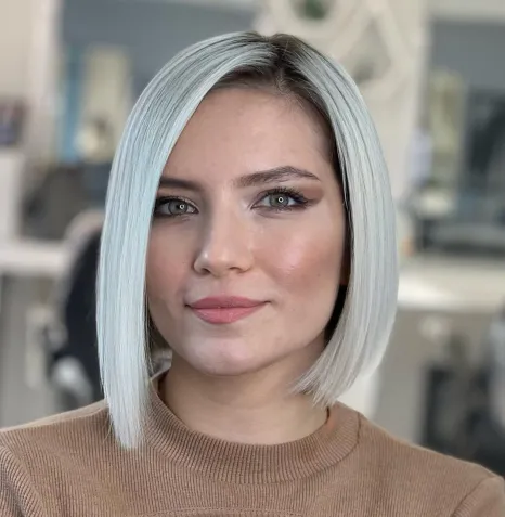 Asimetrični sleek blunt bob z ravnimi linijami, ki poudari ličnice in podaljša okrogel obraz