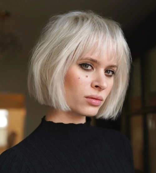 Ženska z tankimi lasmi v bob z ravno linijo in frufrujem, frizura ustvarja videz gostejših las in dodan volumen pri koreninah.