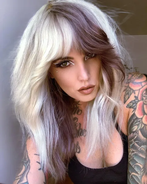 Dekle s kontrastno barvano E-girl frizuro v shag kroju.