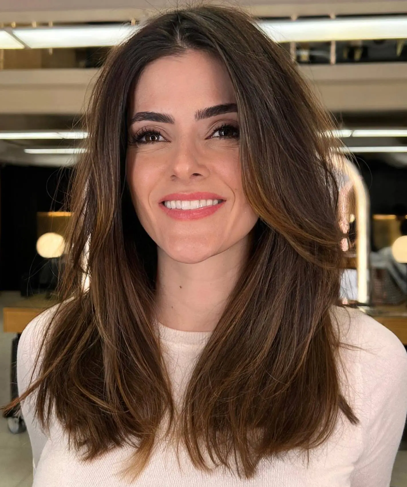 Srednje dolgi lasje s plastenjem po dolžini za trikotni obraz – mehčajo poteze in ustvarijo uravnotežen videz.