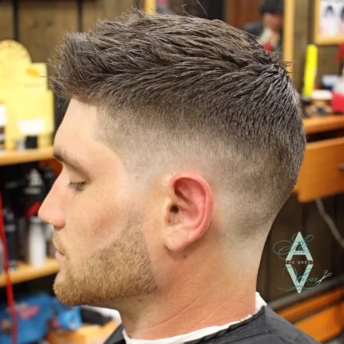 Texturirana kratka moška frizura z mid fade prehodom.